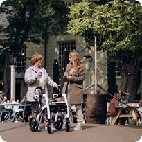 Two women talking beside mobility walkers